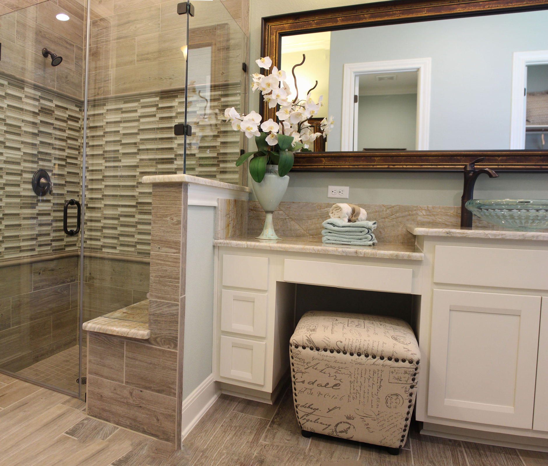 Master bath with white cabinets and vanity seat