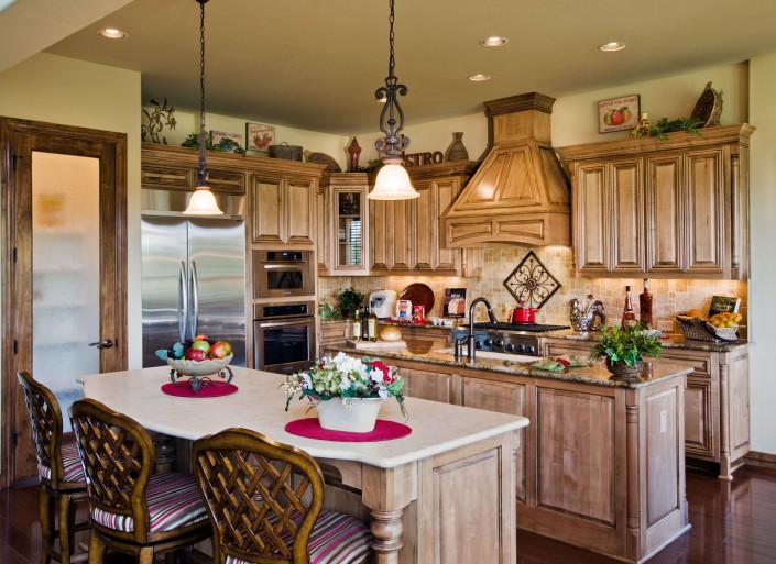 Burrows Cabinets' kitchen with corner posts and custom wood range hood