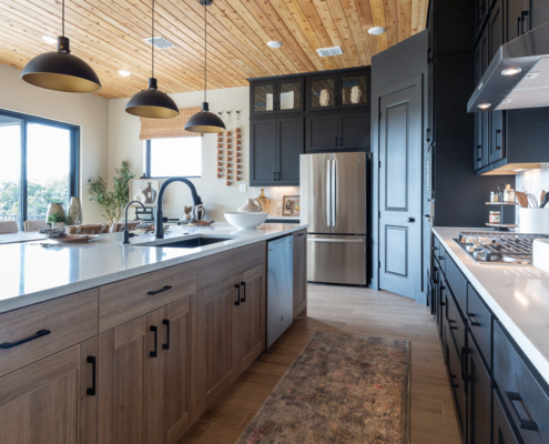 Reveur EVRGRN woodgrain kitchen island with 5pc doors and black perimeter cabinets