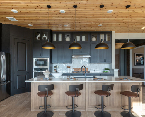 Kitchen with wood shiplap ceiling and Breu black perimeter cabinets and EVRGRN Reveur island and buffet