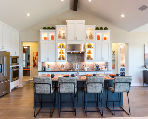 Burrows Cabinets' kitchen with orange accents, Shaker doors in Bone white and Dallas feet