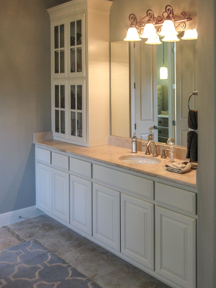 Primary bath with mullion doors on tall corner cabinet in bone white