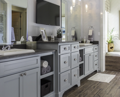 Primary bath cabinets Shaker light blue with open shelves and raised center drawer bank