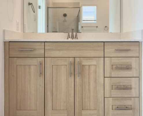 Frameless new home bathroom vanity cabinet in rift white oak look Biscay EVRGRN with 5 piece doors