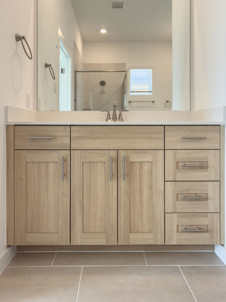 Frameless new home bathroom vanity cabinet in rift white oak look Biscay EVRGRN with 5 piece doors