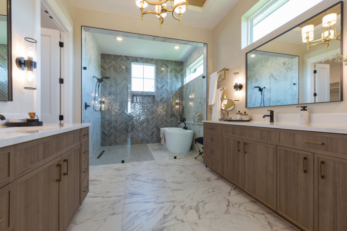 Bathroom vanity cabinets in Reveur medium woodgrain with slim shaker doors and enclosed soaking tub