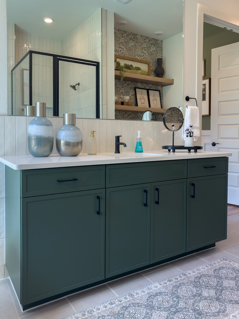 Bathroom vanity cabinets in Saba green with Slim Shaker doors and drawer fronts and black pull handles
