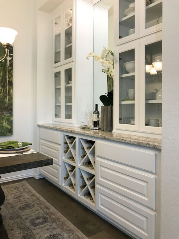 Burrows Cabinets' dining hutch in Frost featuring Big X wine rack, glass and raised panel doors