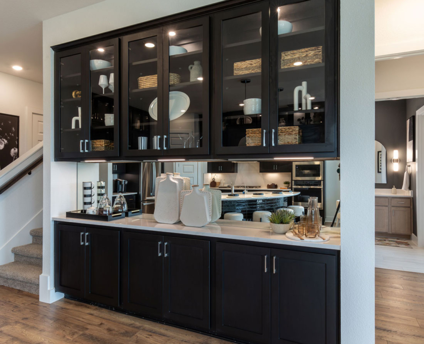 Black built-in buffet cabinets in Breu black paint with glass uppers, shaker doors and mirror backsplash