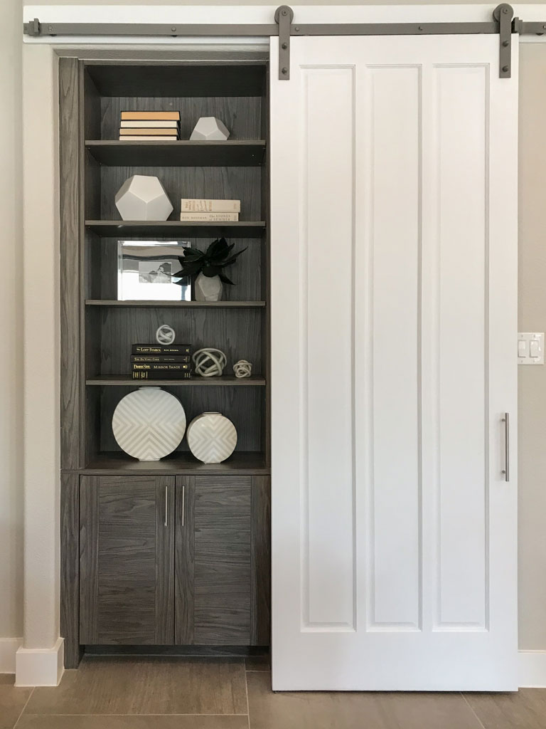 Barn door with bookshelves and cabinet in EVRGRN Rok