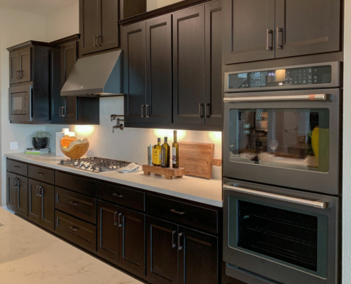 Kitchen wall cabinets by Burrows Cabinets in Beech with dark stain - slate black appliances