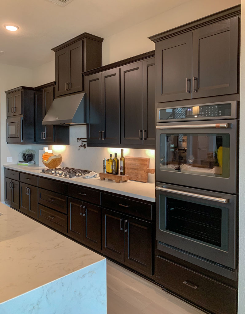 Kitchen wall cabinets in Beech Espresso by Burrows Cabinets with Briscoe doors and slate black appliances