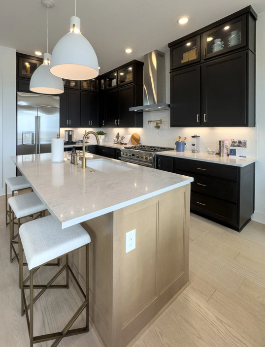 Kitchen with Maple Savaii island cabinets and Breu black perimeter cabinets with Callahan doors and gold hardware pulls