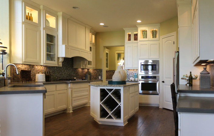 Burrows Cabinets kitchen cabinets with Briscoe door style in Bone, big x wine rack and Elite vent hood