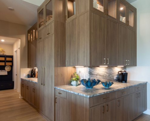 Kitchen corner cabinets in Reveur with Slim Shaker doors, glass uppers and custom refrigerator appliance panels