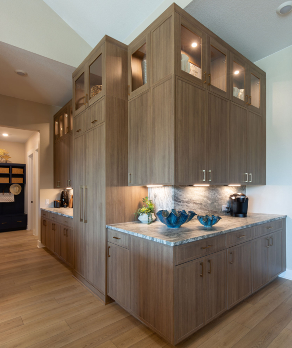 Kitchen corner cabinets in Reveur with Slim Shaker doors, glass uppers and custom refrigerator appliance panels