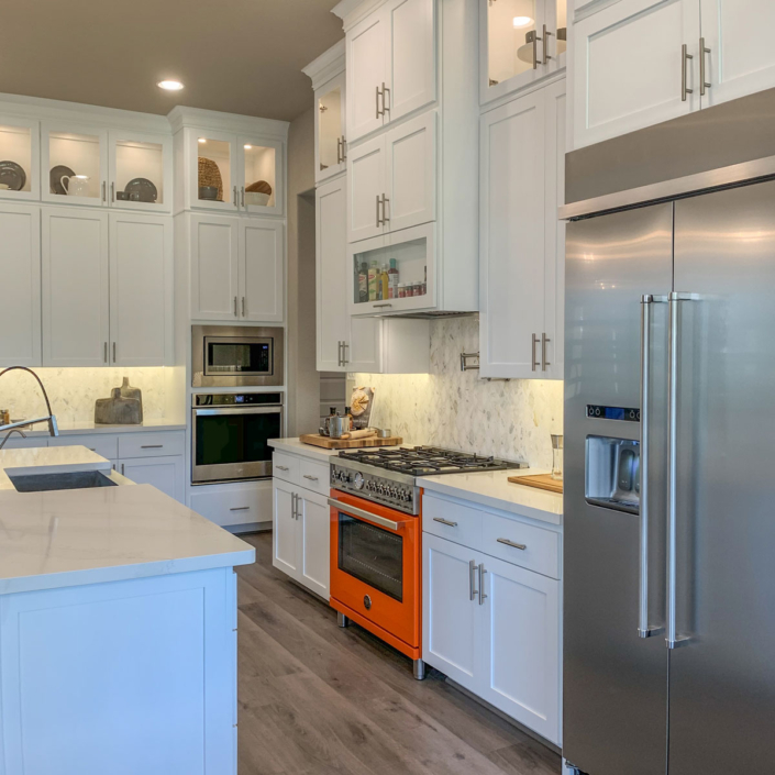 Kitchen with white cabinets, shaker doors, orange Italian oven