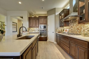 Burrows Cabinets' kitchen cabinets in Beech with Kona stain and glass upper cabinet doors