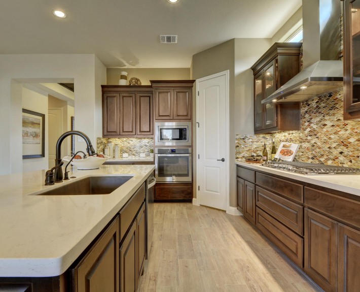 Burrows Cabinets' kitchen cabinets in Beech with Kona stain and glass upper cabinet doors