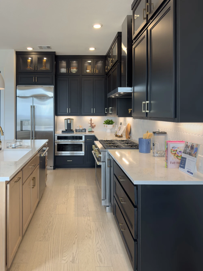 Kitchen Maple Savaii island cabinets, Breu black perimeter cabinets with Callahan doors, tall glass upper cabinets, and gold hardware pulls