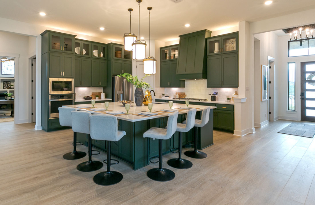 Kitchen cabinets in Saba green with Shaker doors and vent hood