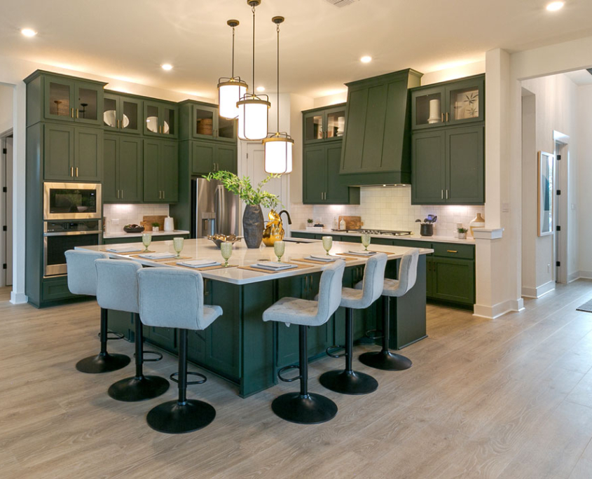 Kitchen cabinets in Saba green with Shaker doors and vent hood