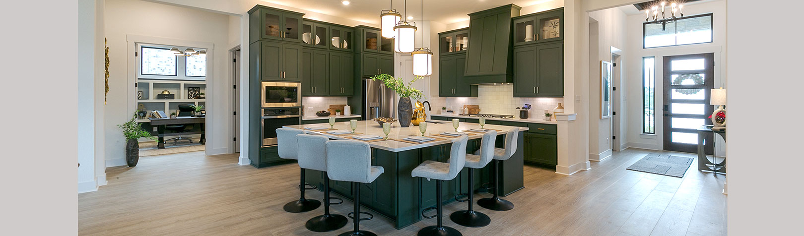 Kitchen with large island, custom vent hood and Shaker doors in Saba green