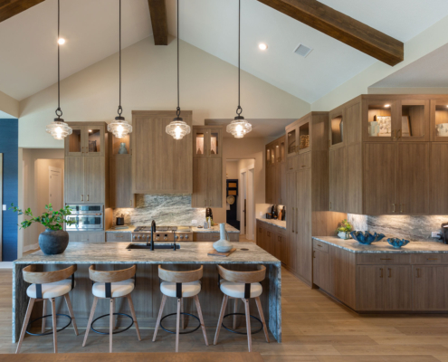 Kitchen with Slim Shaker doors in warm woodgrain Reveur EVRGRN engineered wood, built-in appliance panels, custom vent hood