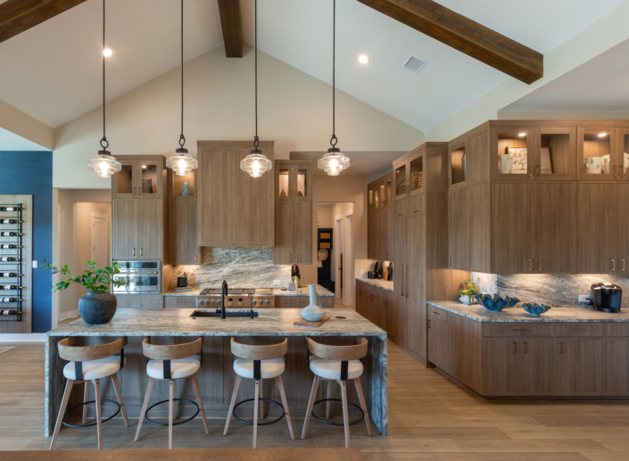 Kitchen with Slim Shaker doors in warm woodgrain Reveur EVRGRN engineered wood, built-in appliance panels, custom vent hood