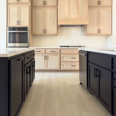 Kitchen cabinets with maple Savaii uppers and Shaker vent hood and Breu black painted island base cabinets