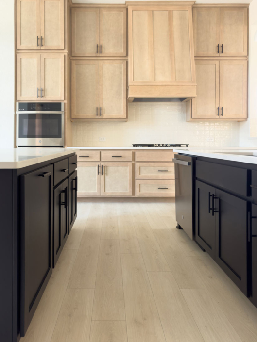 Kitchen cabinets with maple Savaii uppers and Shaker vent hood and Breu black painted island base cabinets