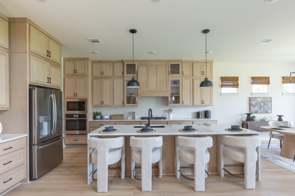 Kitchen cabinets in Maple Savaii with Shaker doors, tall uppers, glass doors, Shaker wood range hood and paneled island back