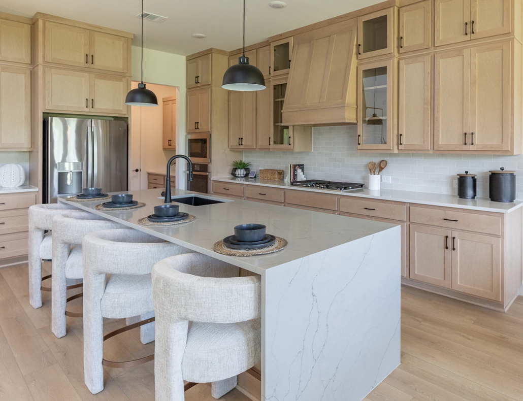 Kitchen in maple Savaii with Shaker doors with black pull handles and custom Shaker wood range hood, refrigerator shroud and waterfall island