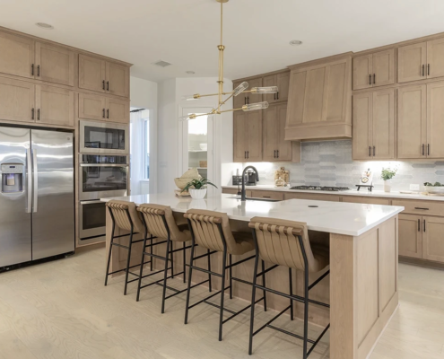 Kitchen cabinets and paneled island in Maple Savaii with Shaker doors and Artisan Hood