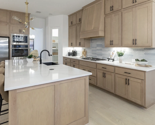 Kitchen cabinets in Maple Savaii with Artisan vent hood, full extension pot drawers and Shaker doors