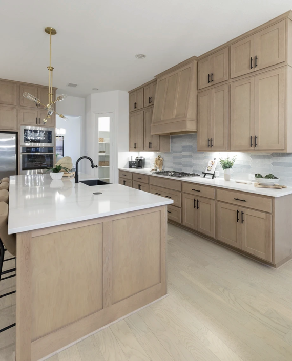 Kitchen cabinets in Maple Savaii with Artisan vent hood, full extension pot drawers and Shaker doors