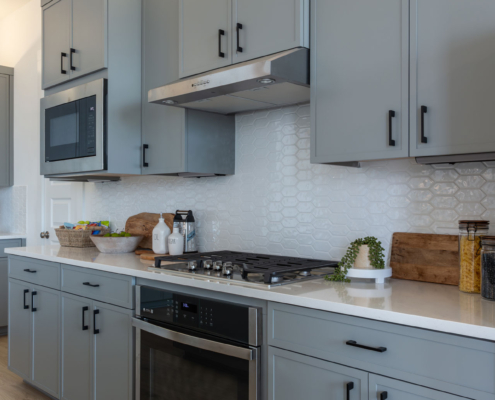 Kitchen perimeter cabinets with Slim Shaker doors in Costa gray and black pull handles