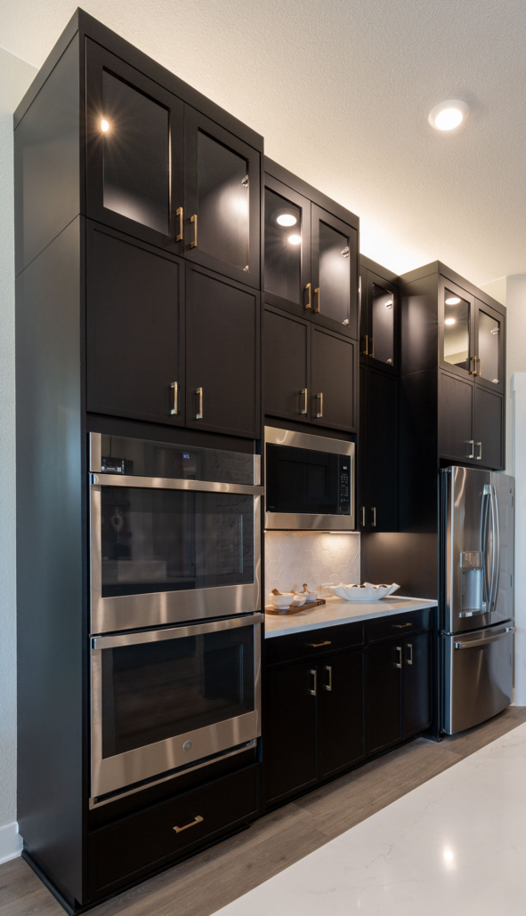 Kitchen oven wall cabinets in Breu muted black paint with Slim Shaker doors and gold pulls