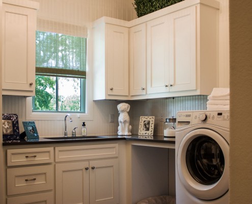 Burrows Cabinets' laundry room cabinets with Kensington doors and dog bed open space