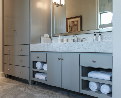 Modern primary bath cabinets in gray with SoCo doors and tall towel and linen storage cabinet