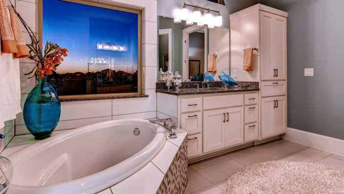 Primary bath with white shaker style cabinets by Burrows Cabinets