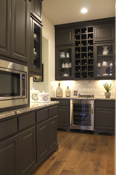 Burrows Cabinets' pantry cabinets with wine storage and glass doors in Umber gray