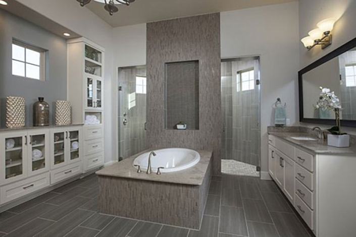Primary bath with white cabinets, glass doors and tall linen cabinet